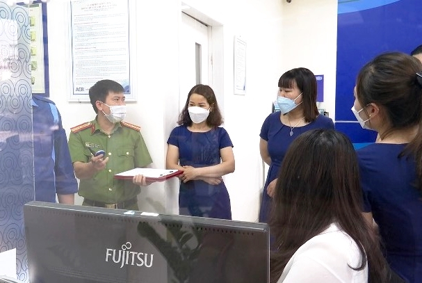 Cán bộ Phòng Kỹ thuật hình sự (Công an tỉnh) hướng dẫn CBNV ACB Quảng Ninh cách sử dụng hệ thống báo động khẩn cấp.