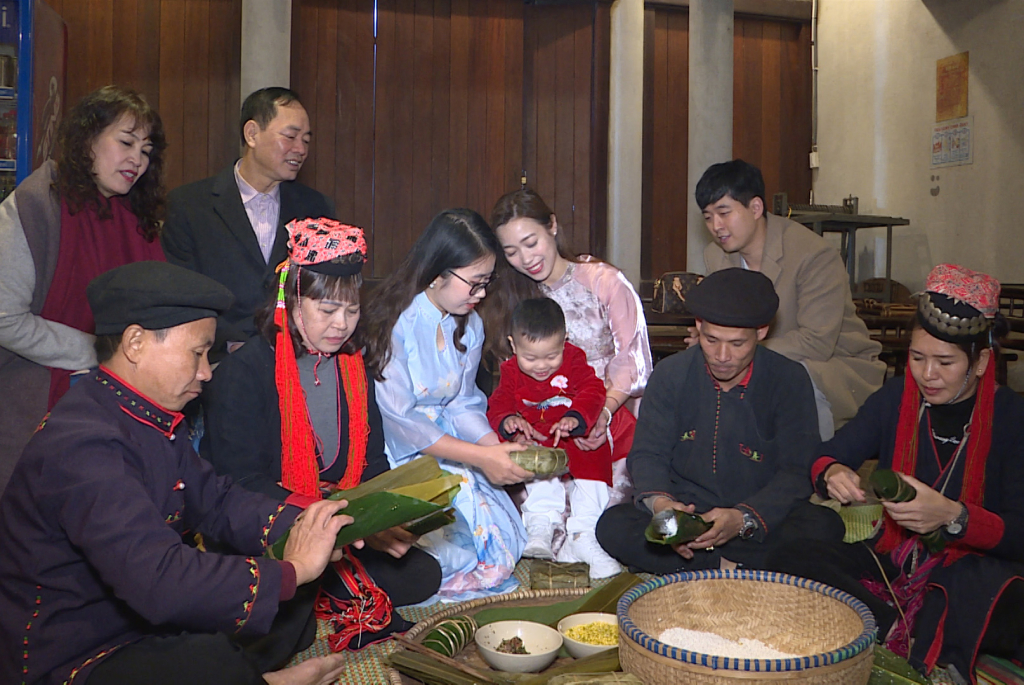 Du khách trải nghiệm gói bánh chưng tại làng Nương Yên Tử. 