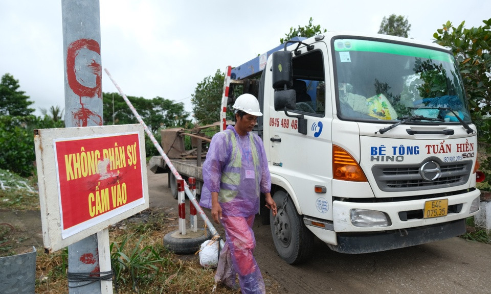 Mưa lớn gây cản trở việc kéo ống cọc bê tông có bé trai 10 tuổi lên