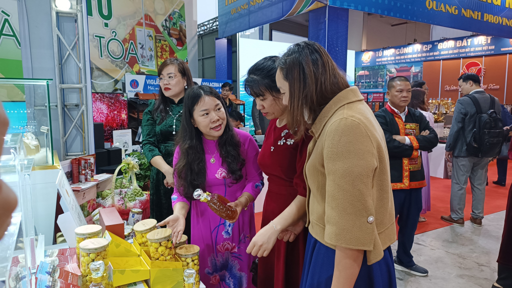 Các đại biểu và nhân dân tham quan, mua sắm ở gian hàng trưng bày, bán các sản phẩm nông sản của tỉnh Quảng Ninh được tổ chức tại hội nghị.