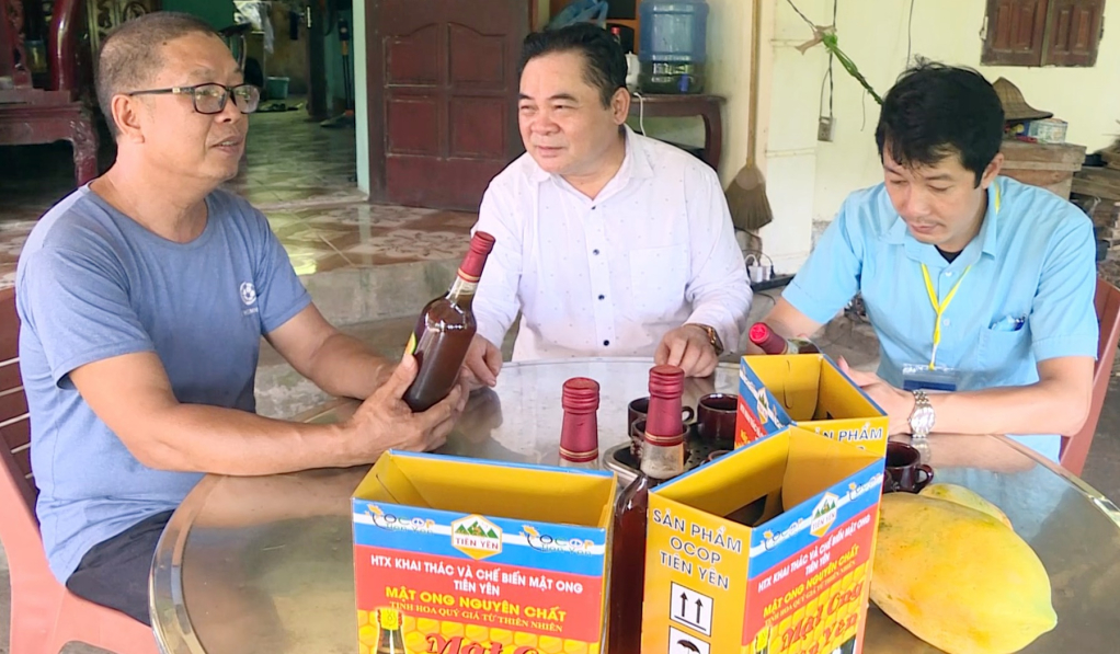 Ông Đào Trọng Nghĩa (bên trái) Giám đốc HTX Khai thác và chế biến mật ong Tiên Yên (xã Tiên Lãng, huyện Tiên Yên) tự hào khi sản phẩm mật ong của HTX luôn chiếm lĩnh trên thị trường.