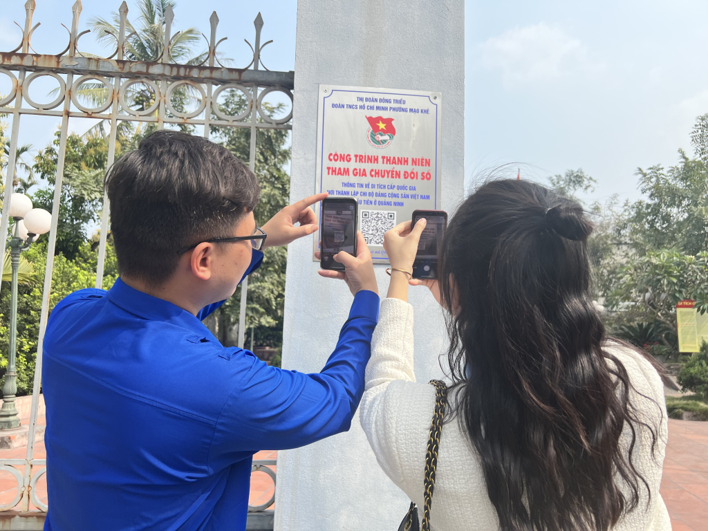 Bí thư Đoàn thanh niên Mạo Khê hướng dẫn người dân quét QR code ở nơi thành lập Chi bộ Đảng đầu tiên ở Quảng Ninh.