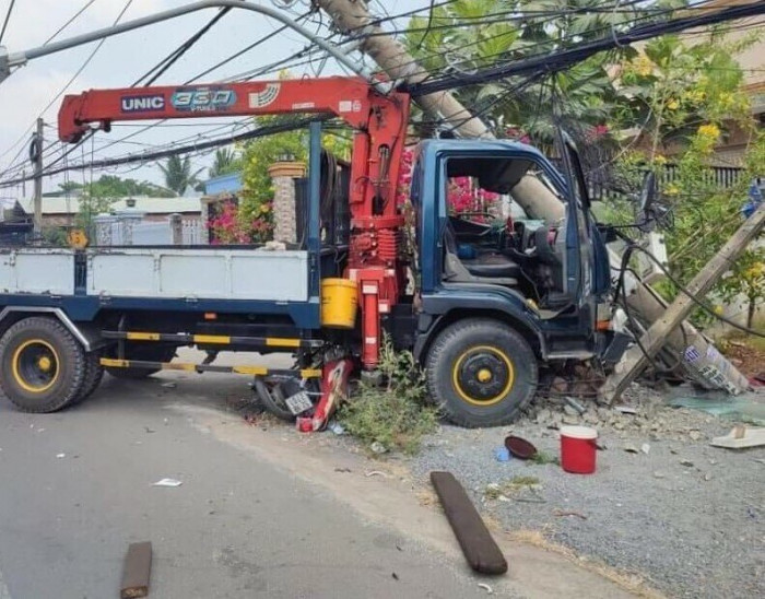 Xe tải cẩu lao qua đường tông xe máy, húc gãy trụ điện, 1 người tử vong 1