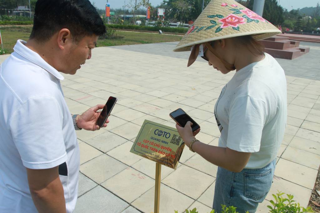 Du khách quét mã QR nghe thuyết minh tự động tại tại Di tích quốc gia đặc biệt khu lưu niệm Chủ tịch Hồ Chí Minh trên đảo Cô Tô. 