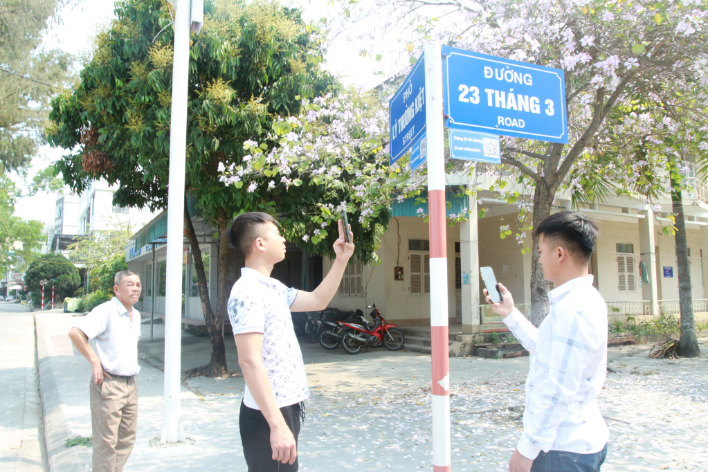 Du khách quét mã QR trên đường phố Cô Tô. 
