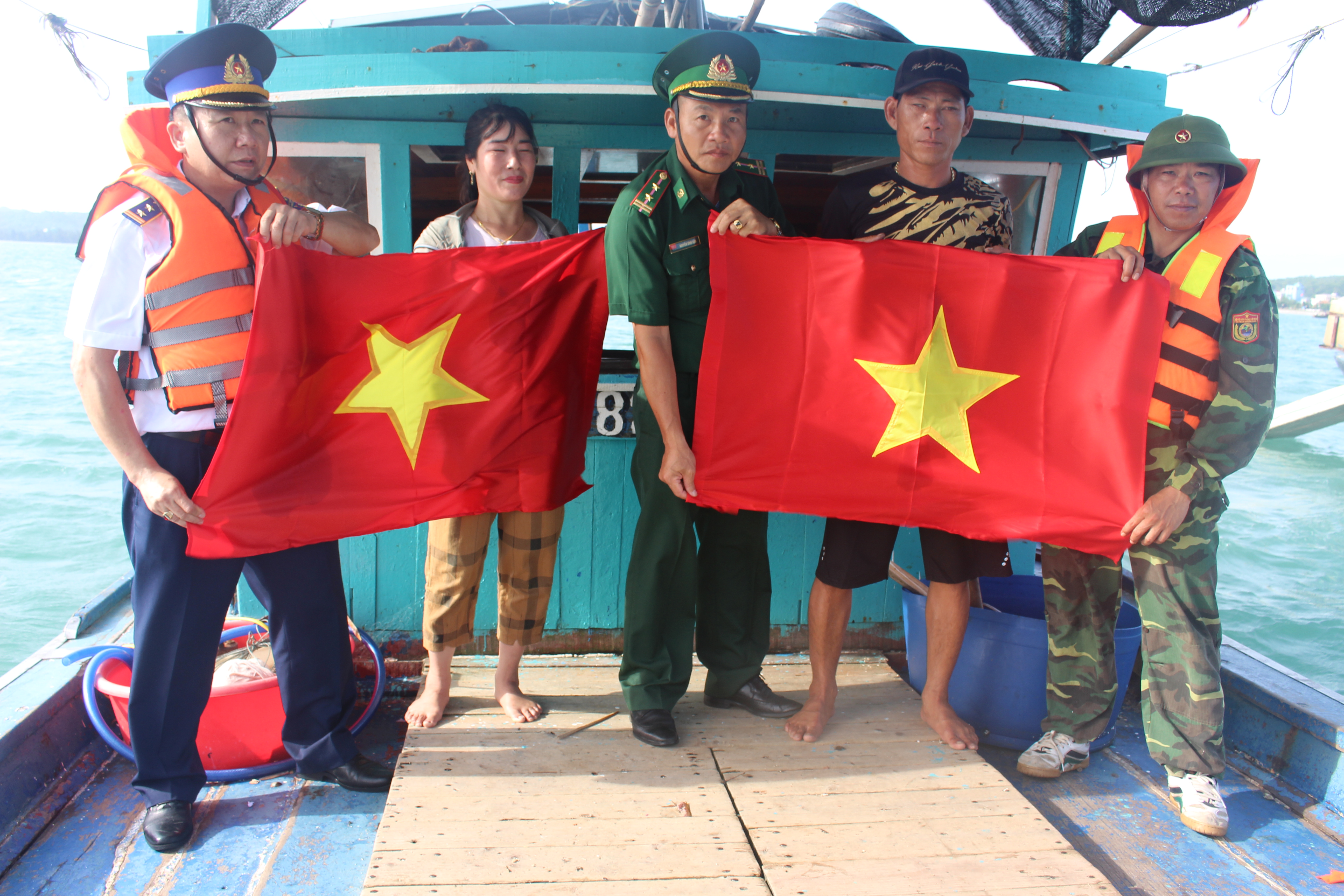 Chiến sĩ Đồn biên phòng Cô Tô tặng cờ Tổ quốc cho ngư dân bám biển.