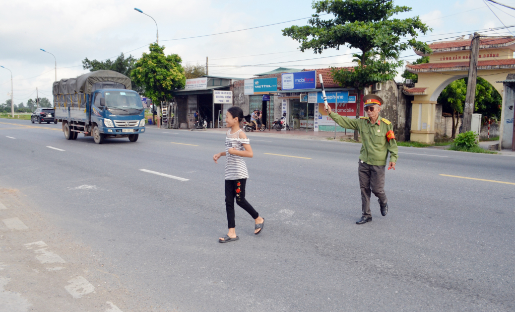 CCB Phạm Đức Hạnh báo hiệu phương tiện nhường đường cho học sinh đi qua.