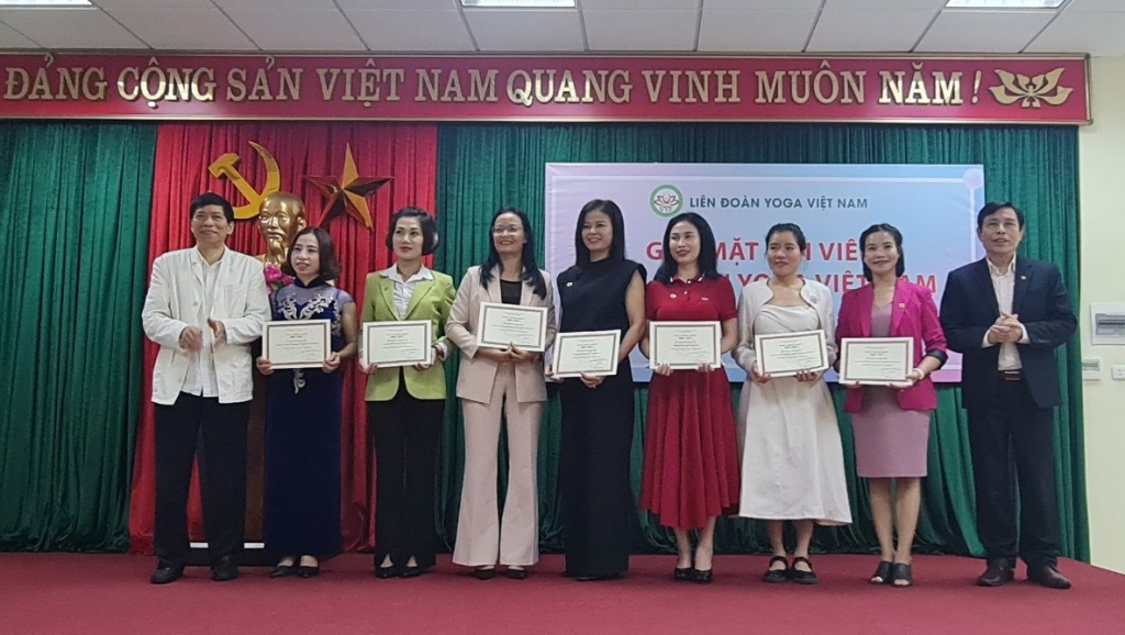 Ông Trần Đình Tuấn, Chủ tịch Liên đoàn Yoga Việt nam trao chứng nhận hội viên mới trong liên đoàn  