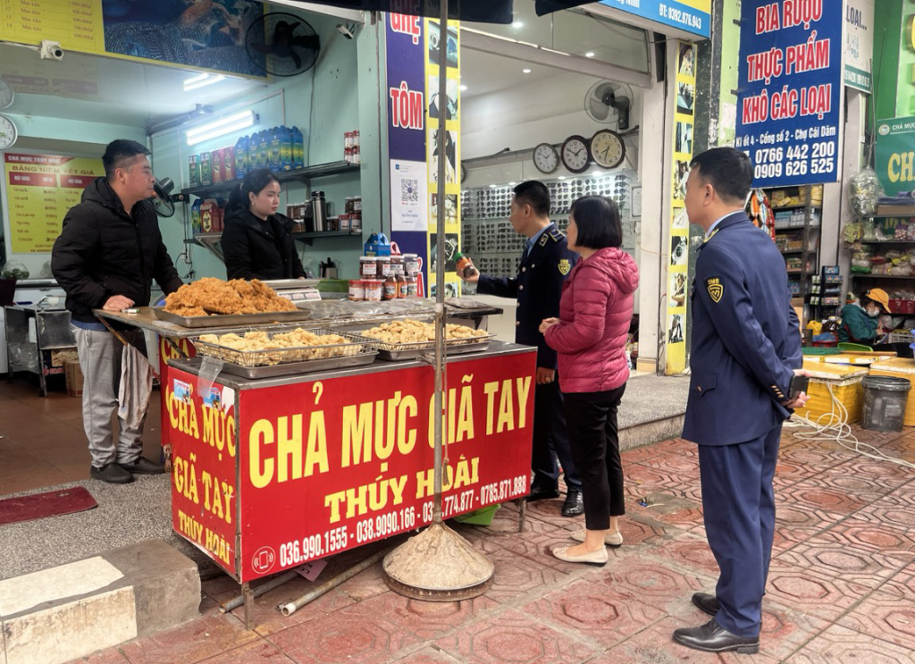 Cán bộ Đội QLTT số 5 tuyên truyền các quy định về đảm bảo vệ sinh ATTP cho một hộ kinh doanh thực phẩm tại chợ Cái Dăm (phường Bãi Cháy, TP Hạ Long). (Ảnh: Đội QLTT số 5)