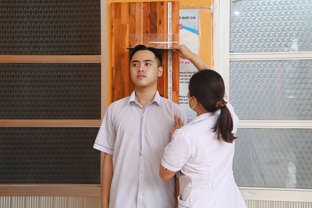 Công dân phương Hoành Bồ (TP Hạ Long)  được cán bộ y tế phường đo chiều cao, cân nặng, vòng ngực.