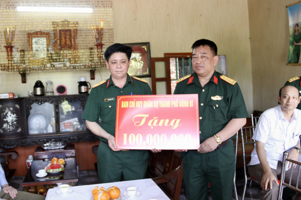  Thượng tá Nguyễn Tiến Vinh, Chỉ huy trưởng Ban CHQS thành phố Uông Bí, trao số tiền hỗ trợ cho đồng chí Trần Đình Huyễn.