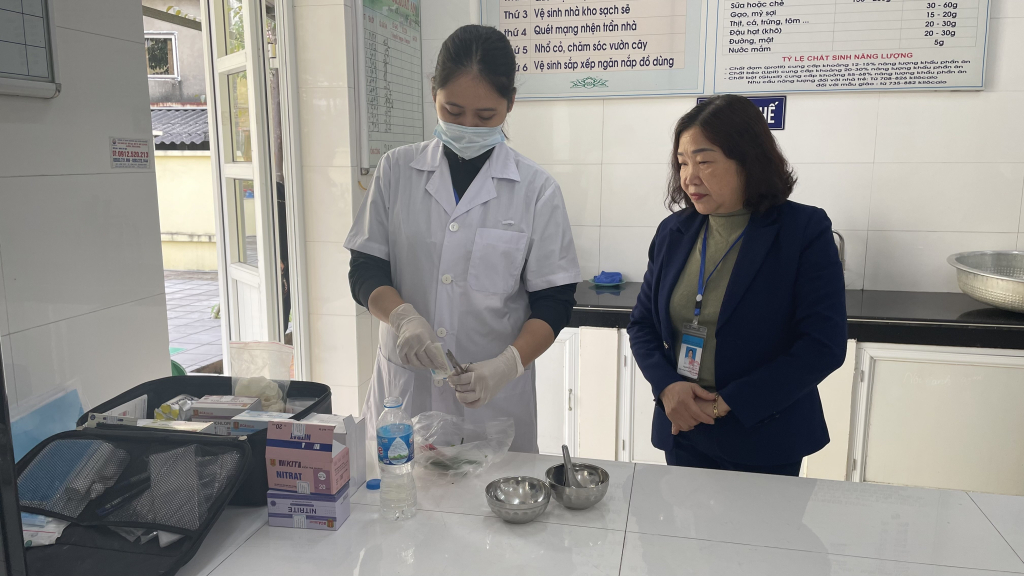 Cán bộ Trung tâm Y tế TP Cẩm Phả test nhanh mẫu thực phẩm sơ chế tại bếp ăn Trường Mầm non Cẩm Đông (TP Cẩm Phả). Ảnh: Lan Anh