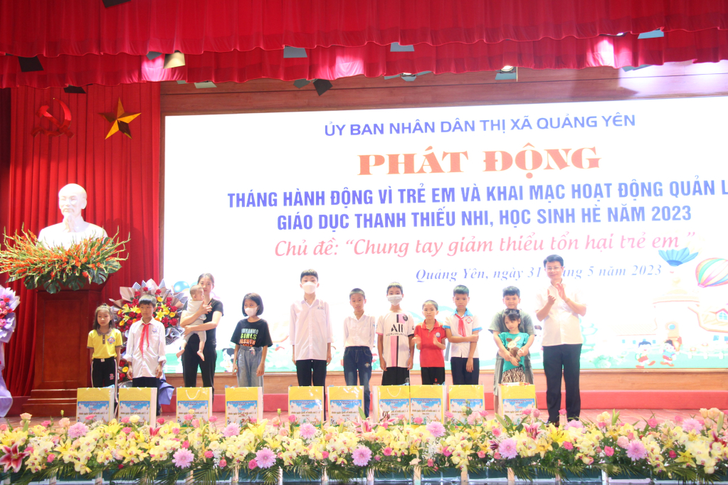 Đồng chí Dương Văn Hào, Phó Chủ tịch UBND thị xã Quảng Yên trao quà của UBND tỉnh cho các em học sinh