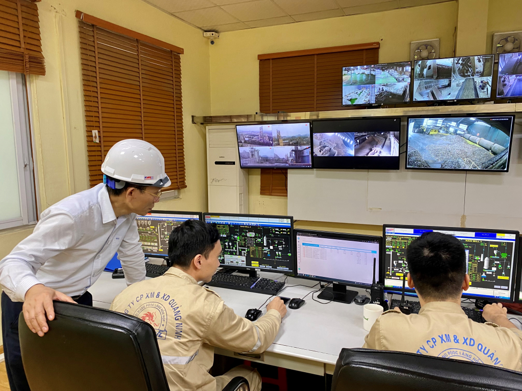 Lãnh đạo Công ty Cổ phần xi măng và xây dựng Quảng Ninh giám sát các thông số quan trắc môi trường tại phòng vận hành trung tâm của Nhà máy xi măng Lam Thạch 2. Ảnh: Hoàng Nga