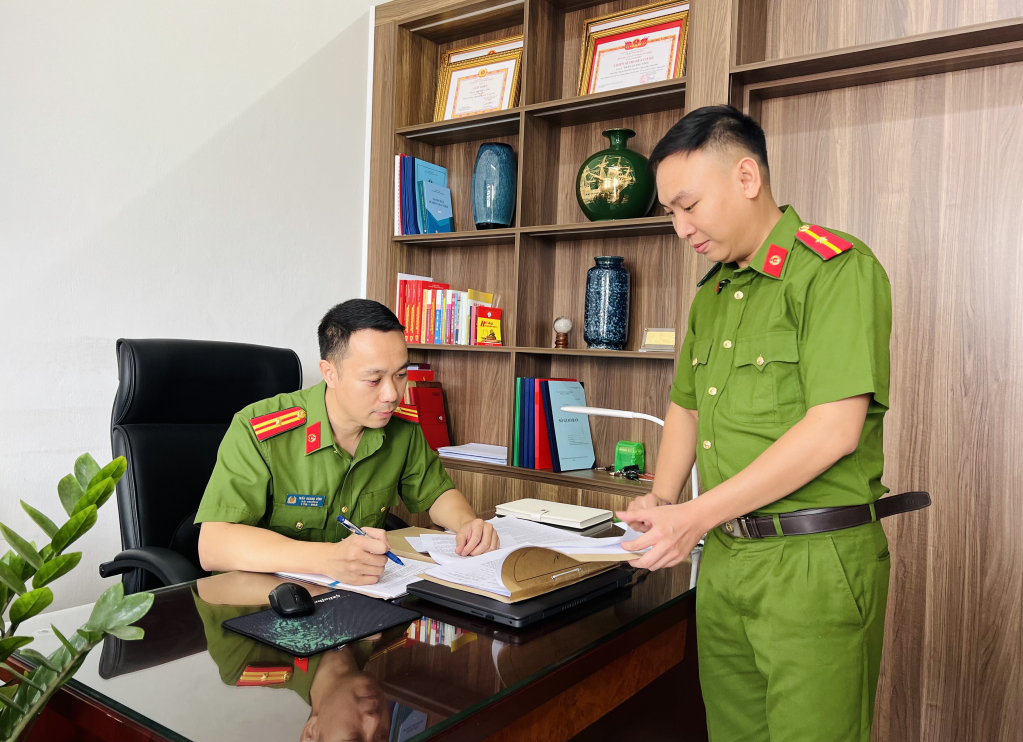 Thiếu tá Trần Quang Vĩnh (ảnh trái) nghe cán bộ báo cáo vụ việc.