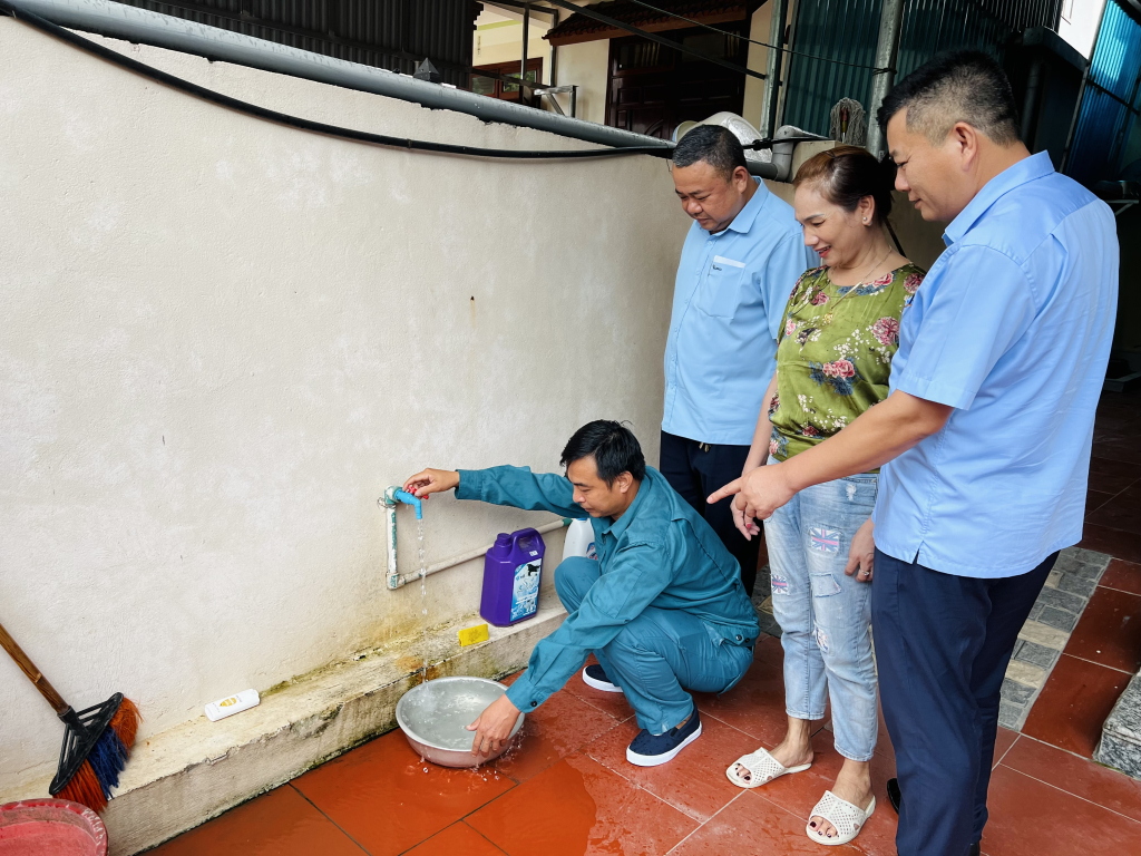 Lãnh đạo Xí nghiệp nước Vân Đồn cùng chị Hà Thị Quyết kiểm tra nước sinh hoạt sau khi lắp đặt đường ống nước sạch.