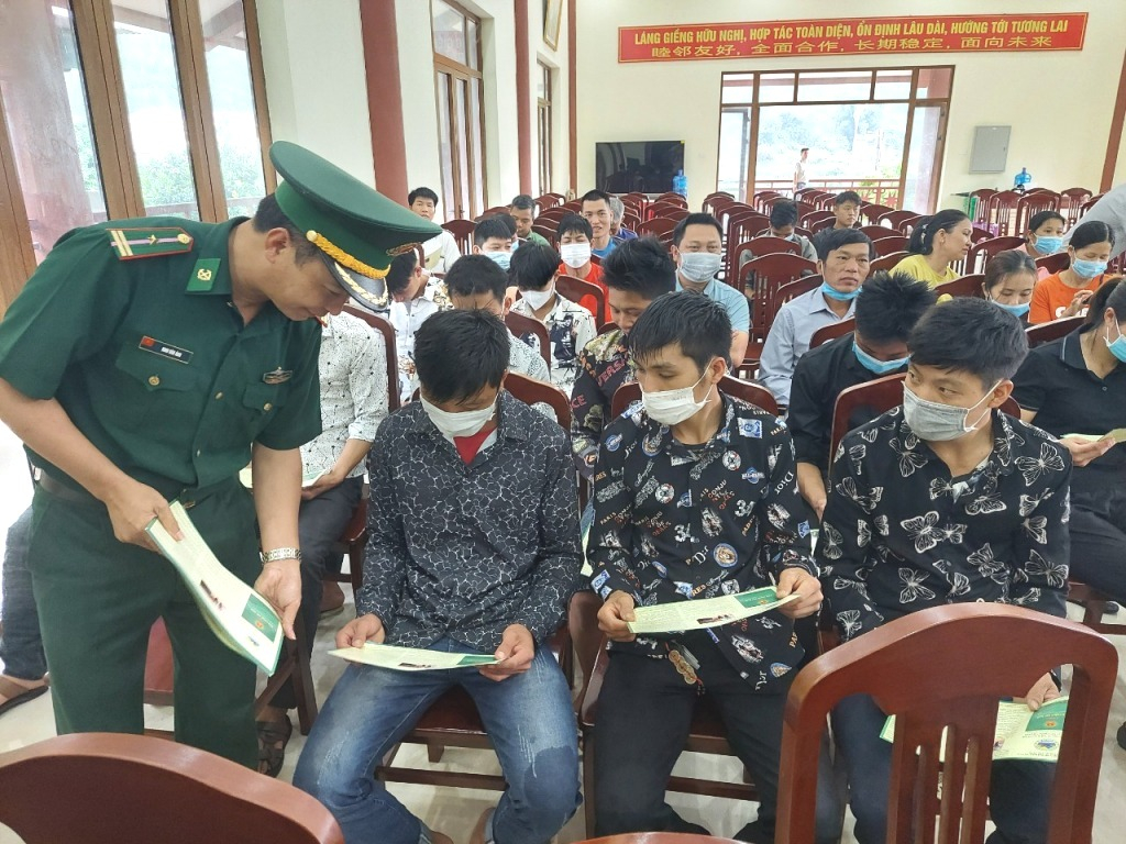 Cán bộ biên phòng phát tờ rơi tuyên truyền Luật Biên phòng cho cán bộ và người dân xã Đồng Văn (huyện Bình Liêu) vào tháng 5-2022. Ảnh: Nguyễn Chiến