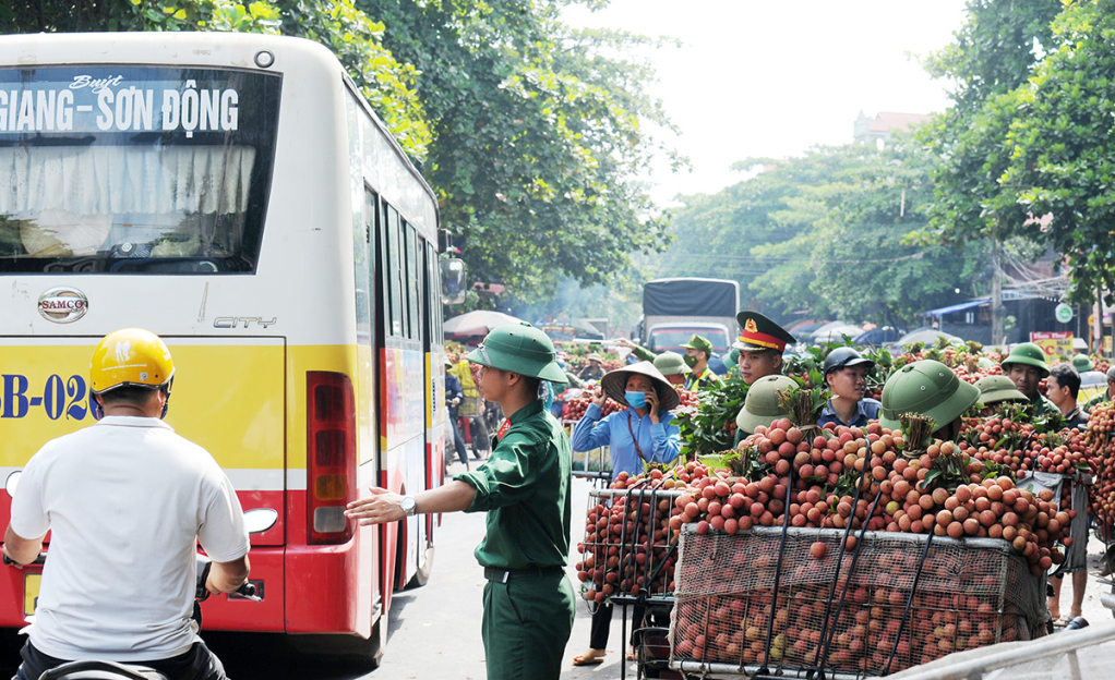Các lực lượng tham gia điều tiết giao thông tại phố Kim, xã Phượng Sơn (Lục Ngạn) giúp người dân tiêu thụ vải thiều thuận lợi.
