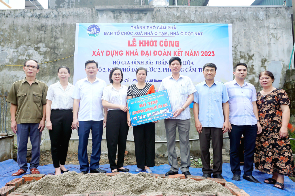 Đại diện lãnh đạo TP Cẩm Phả và phường Cẩm Thủy trao 80 triệu đồng hỗ trợ cho bà Hòa để giúp bà xây nhà