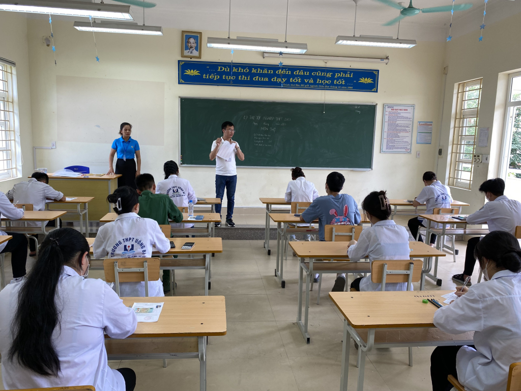 Cán bộ coi thi hướng dẫn thi sinh điền các thông tin vào phiếu trả lời trắc nghiệm của môn Toán tại điểm thi trường THPT Uông Bí. 