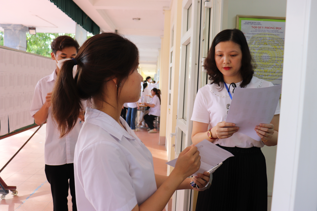 Giám thị tại điểm trường THPT Bạch Đằng (TX Quảng Yên) kiểm tra thông tin thí sinh kỹ lưỡng trước khi vào phòng thi.