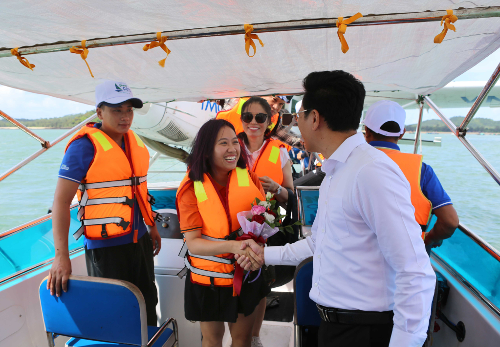 Đồng chí Nguyễn Việt Dũng - Bí thư Huyện ủy, Chủ tịch UBND huyện tặng hoa chúc mừng những vị khách  đến với Cô Tô trên chuyến bay đầu tiên thủy phi cơ. Ảnh: Hoàng Phương - Trung tâm VH-TT huyện Cô Tô