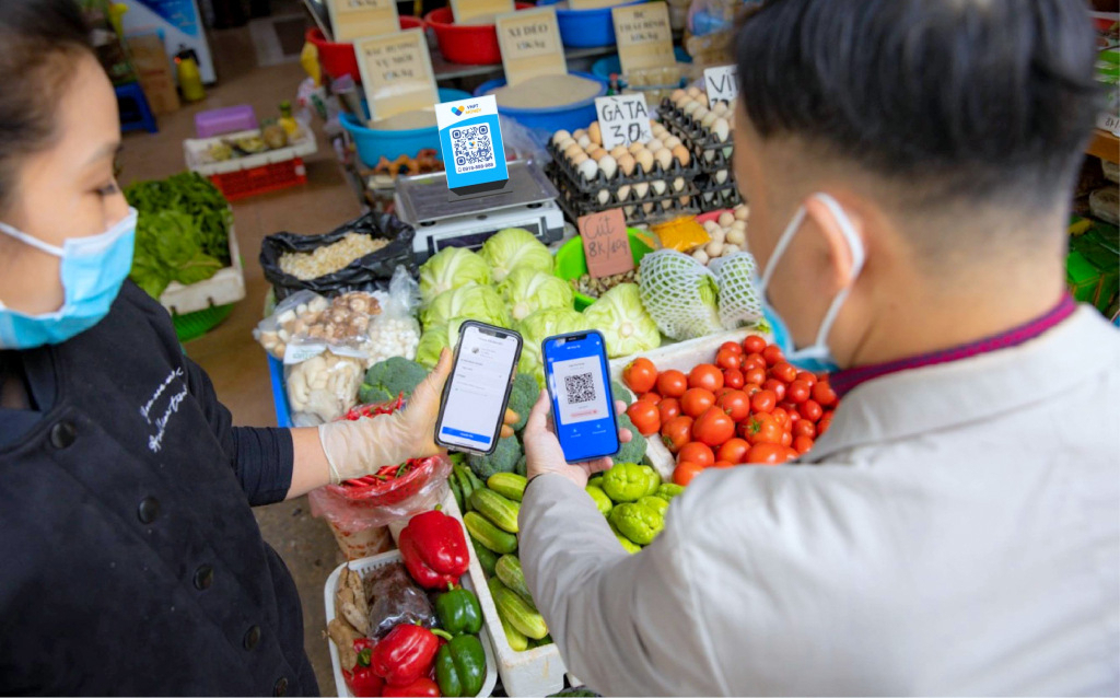 Khách hàng và các tiểu thương giao dịch trực tuyến không dùng tiền mặt quét mã QR tại chợ Hạ Long 2. Ảnh: Minh Hà