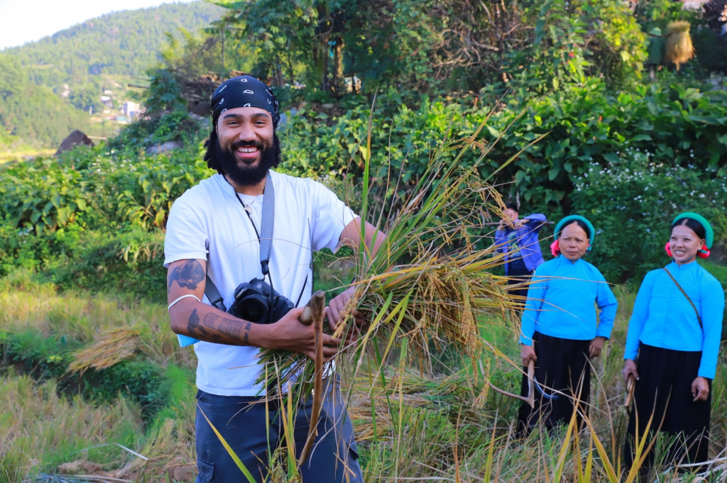 Du khách nước ngoài thích thú trải nghiệm cắt lúa cùng bà con trên cánh đồng ruộng bậc thang. Ảnh: Nguyễn Dung