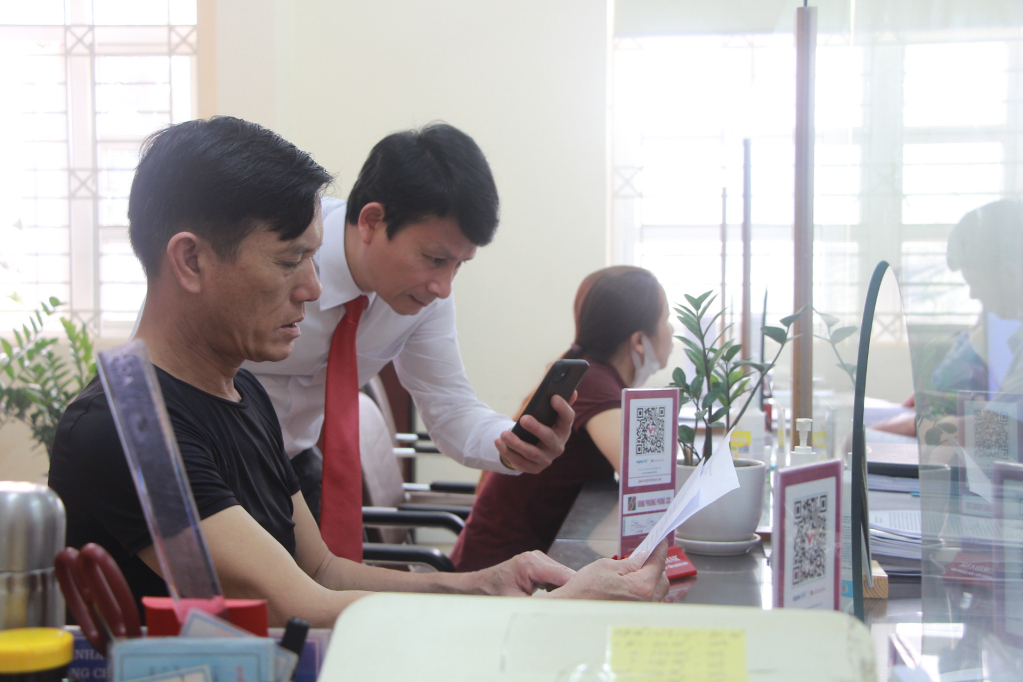 Đồng chí Dương Văn Hào, Phó Chủ tịch UBND TX Dương Văn Hào, kiểm tra hệ thống không dùng tiền mặt khi giao dịch tại Bộ phận một cửa ở phường Phong Cốc.