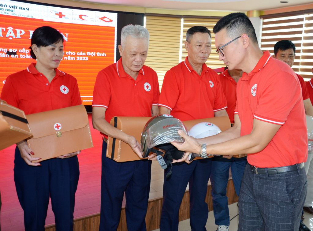 Ông Nguyễn Tuấn Anh, Phó Chủ tịch Hội Chữ thập đỏ tỉnh trao tặng mũ bảo hiểm cho các tình nguyện viên ATGT.