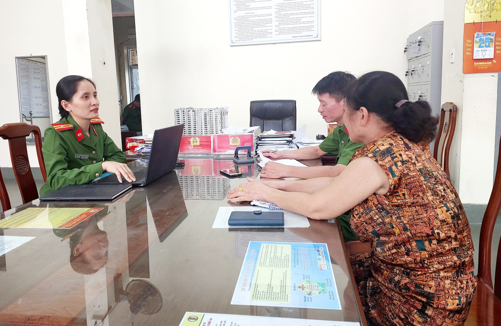 Thiếu tá Thu Giang cùng cán bộ công an phường Quang Trung hỗ trợ, tư vấn cho Nhân dân đăng ký tài khoản định danh điện tử.