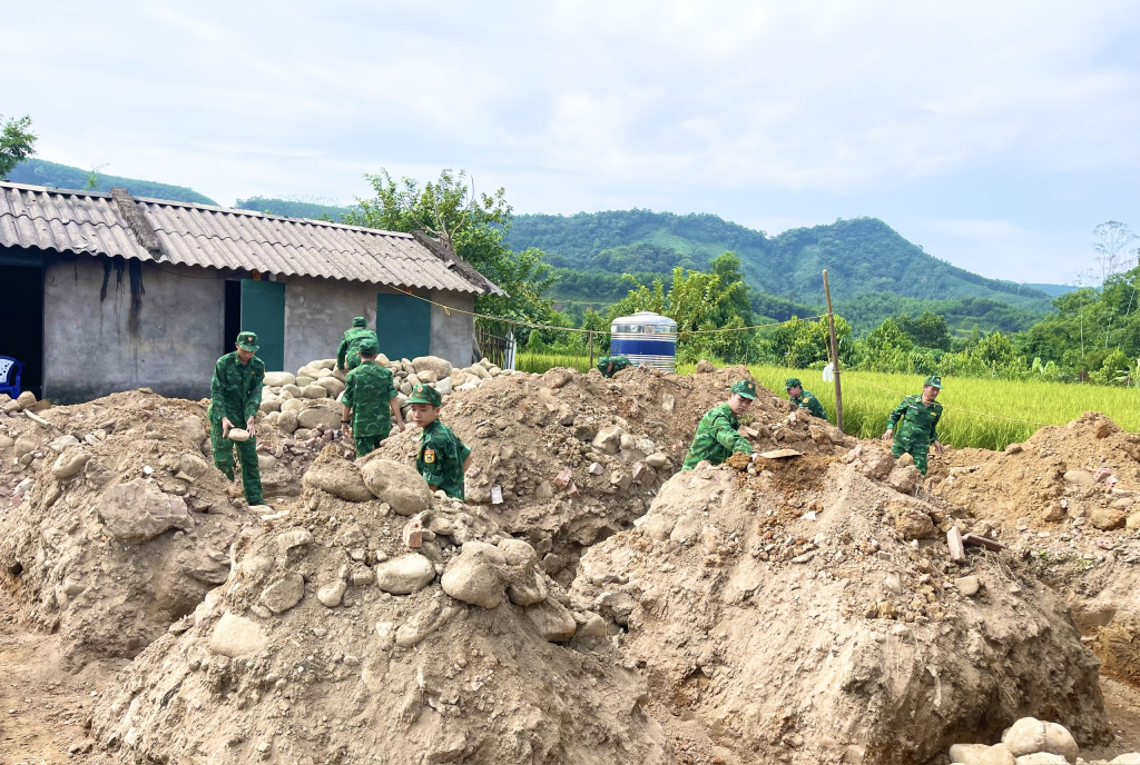 Cán bộ, chiến sĩ Đồn Biên phòng Quảng Đức hỗ trợ ngày công giúp gia đình chị Lý Thị Thắm, bản Chăn Mùi, xã Quảng Đức (Hải Hà)  xây nhà ở. Ảnh: Thái Hà (Trung tâm TT&VH Hải Hà)