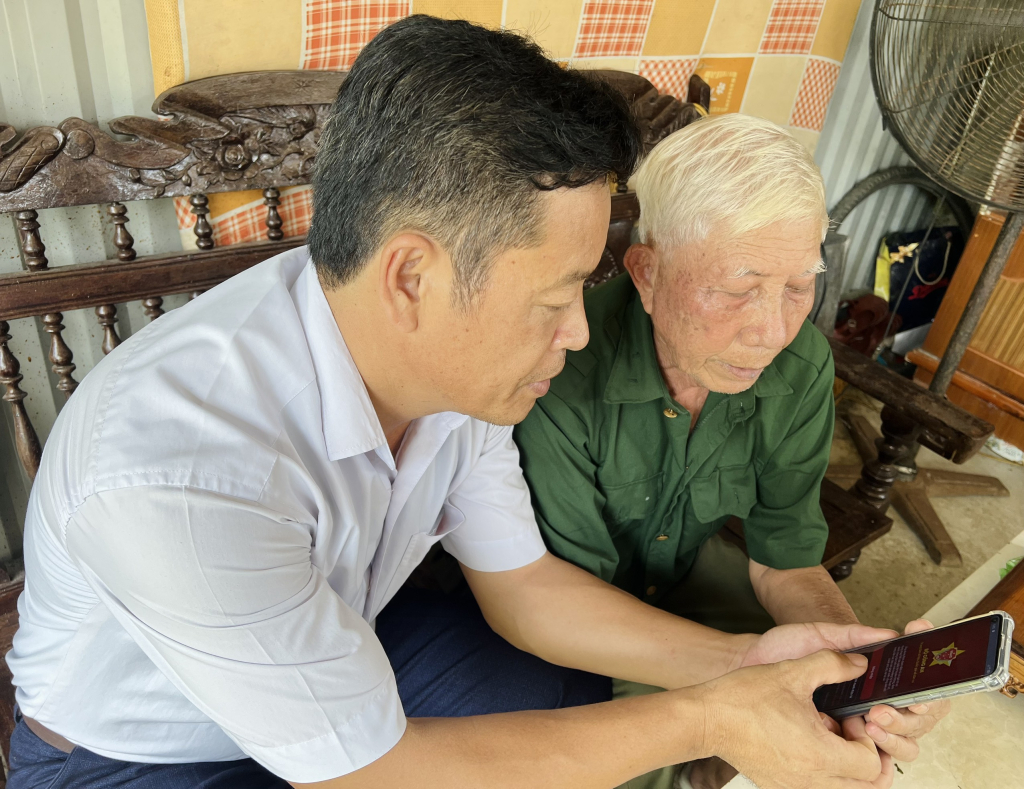 Cựu chiến binh Nguyễn Văn Thơm (áo xanh) cùng đồng đội nghiên cứu ứng dụng định danh điện tử công dân (VNeID).