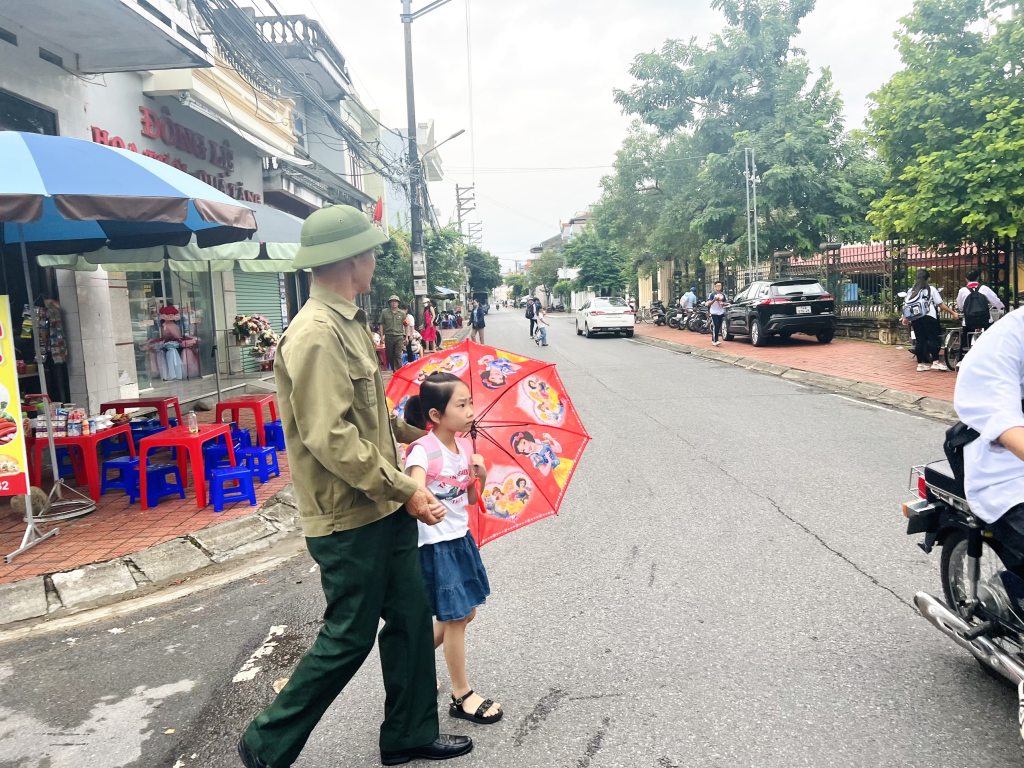 Cựu chiến binh Đặng Văn Cơ trong một buổi điều tiết giao thông khu vực trường Tiểu học thị trấn Quảng Hà.
