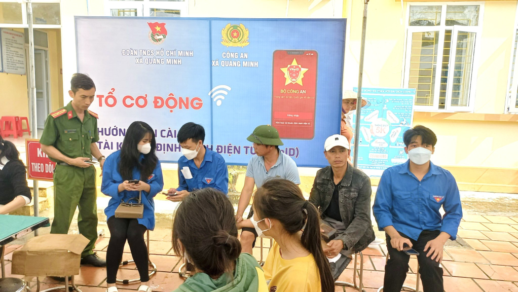 Đảng viên Phạm Văn Lộc (áo xanh, ngồi giữa) cùng Tổ công tác hỗ trợ người dân cài đặt ứng dụng VNeID.