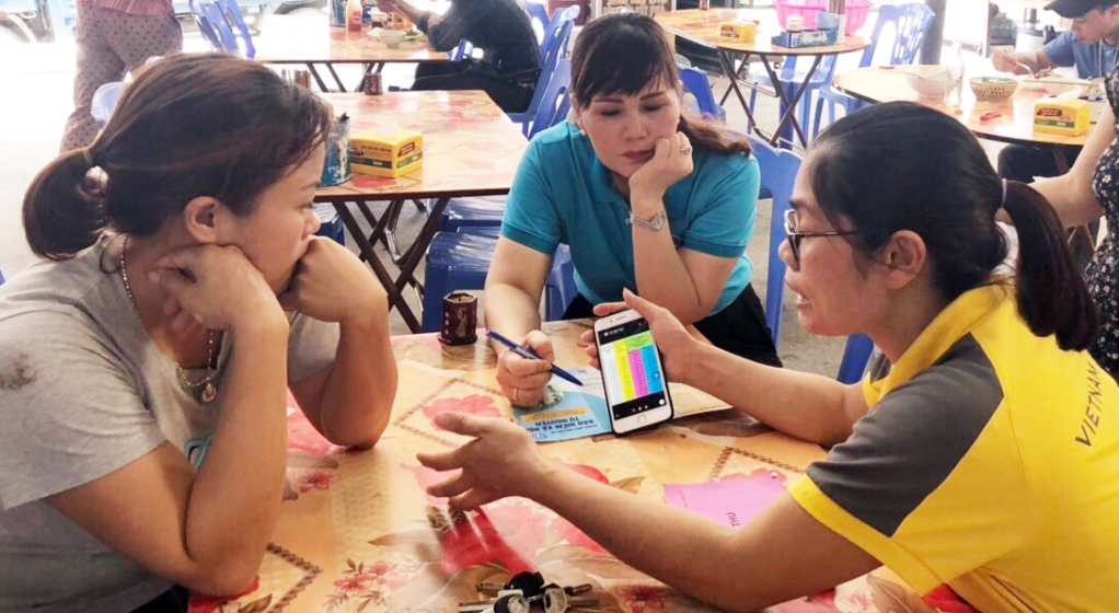Cán bộ BHXH TP Uông Bí và Bưu điện TP Uông Bí tuyên truyền hướng dẫn các mức đóng BHXH tự nguyện cho tiểu thương tại phường Quang Trung TP Uông Bí.