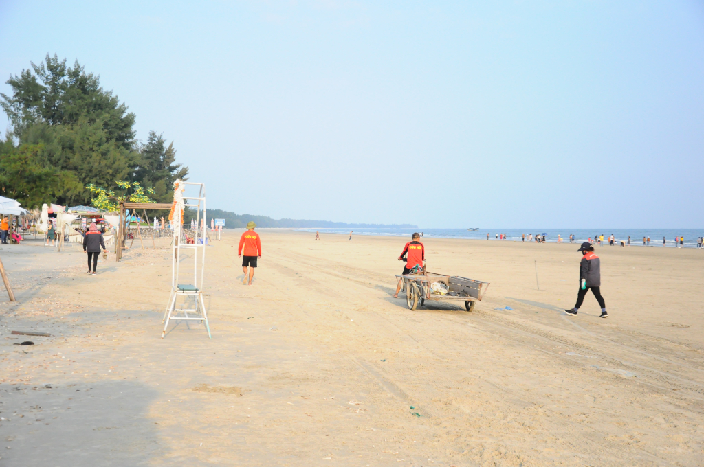 Nhân viên Ban quản lý Khu du lịch Trà Cổ thu gom rác trên bãi biển Trà Cổ