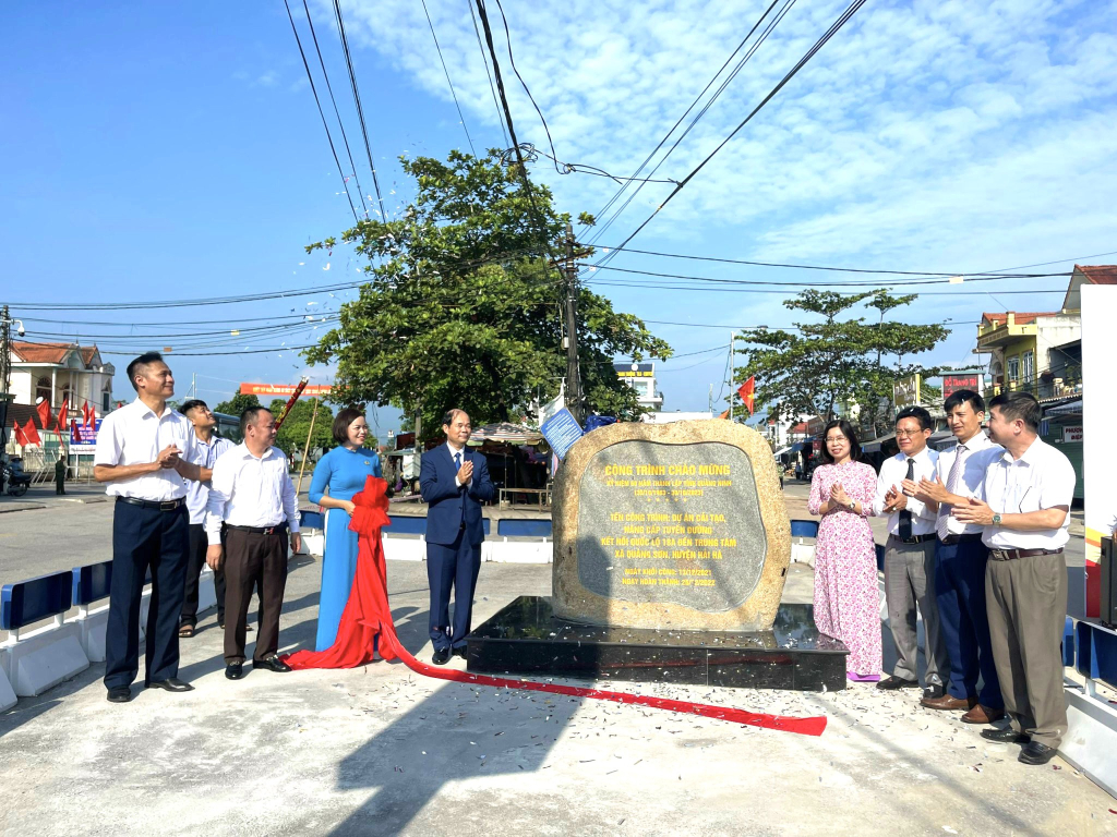Các đại biểu thực hiện nghi thức gắn biển công trình Dự án Cải tạo, nâng cấp tuyến đường kết nối Quốc lộ 18A đến trung tâm xã Quảng Sơn, huyện Hải Hà.