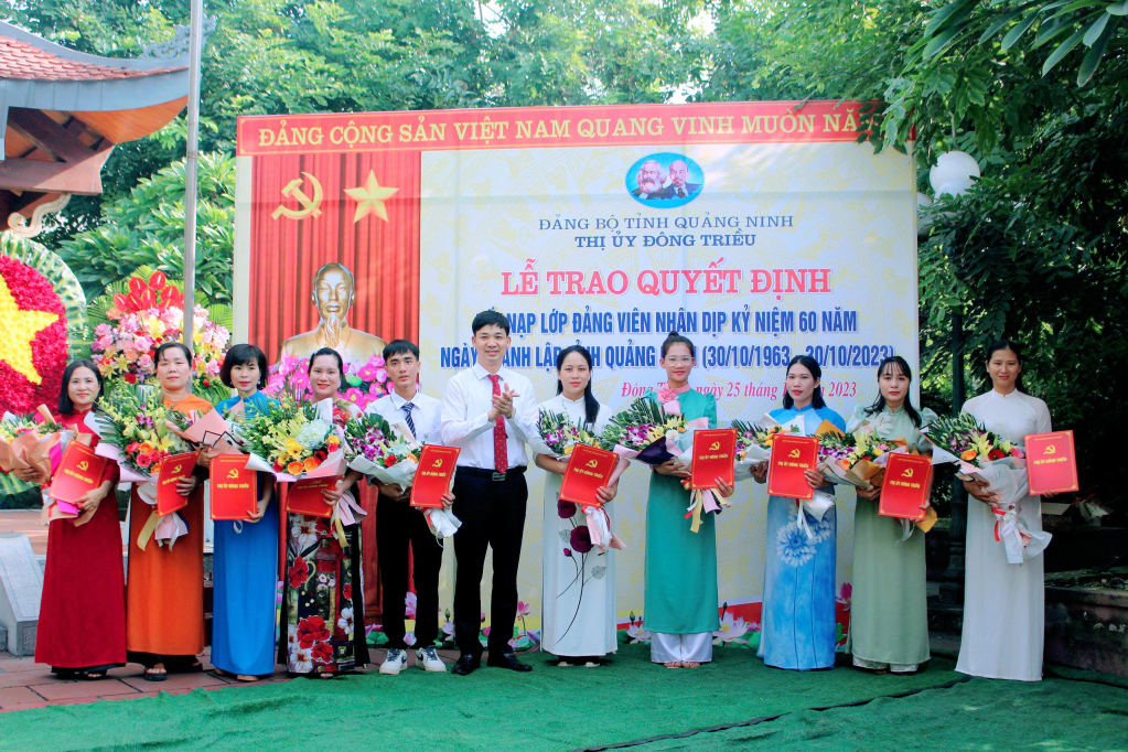 Đồng chí Nguyễn Văn Công, Bí thư Thị ủy Đông Triều trao quyết định kết nạp Đảng cho các quần chúng ưu tú của Lớp đảng viên 60 năm. Ảnh: Trung tâm TT&VH Đông Triều.