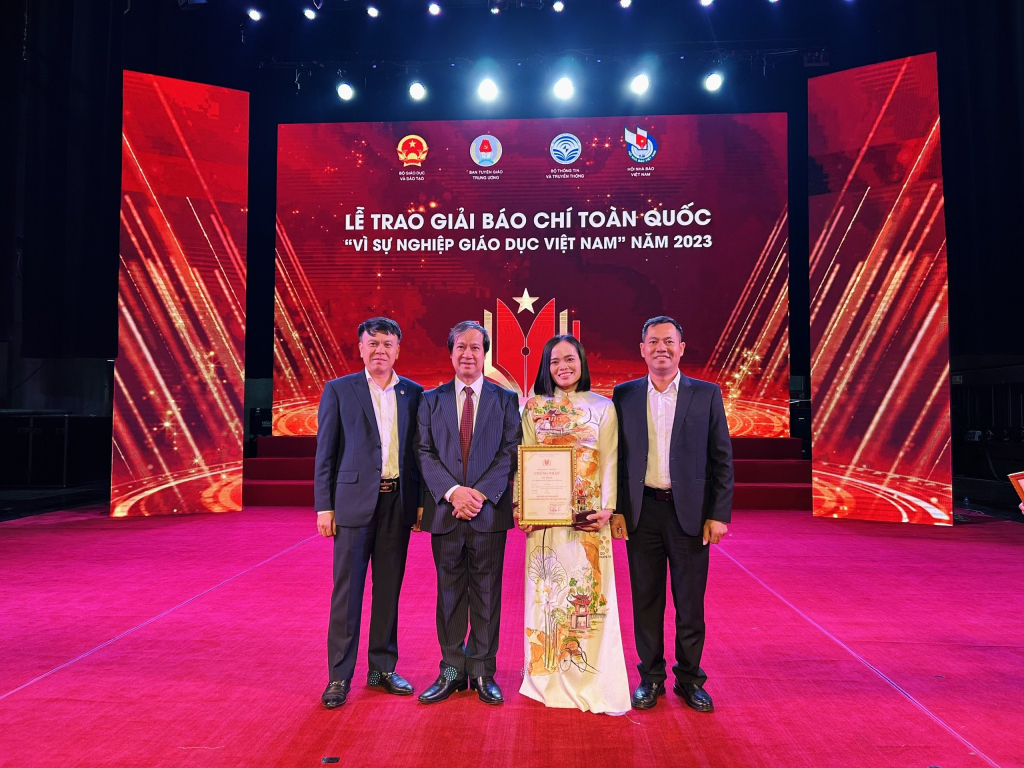 Phóng viên Thu Báu nhận giải ba từ Bộ trưởng Bộ GD - ĐT Nguyễn Kim Sơn trao tặng.