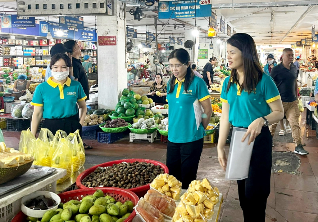 Thanh niên Ngân hàng BIDV Hạ Long tuyên truyền về chuyển đổi số cho các tiểu thương tại chợ Hạ Long.