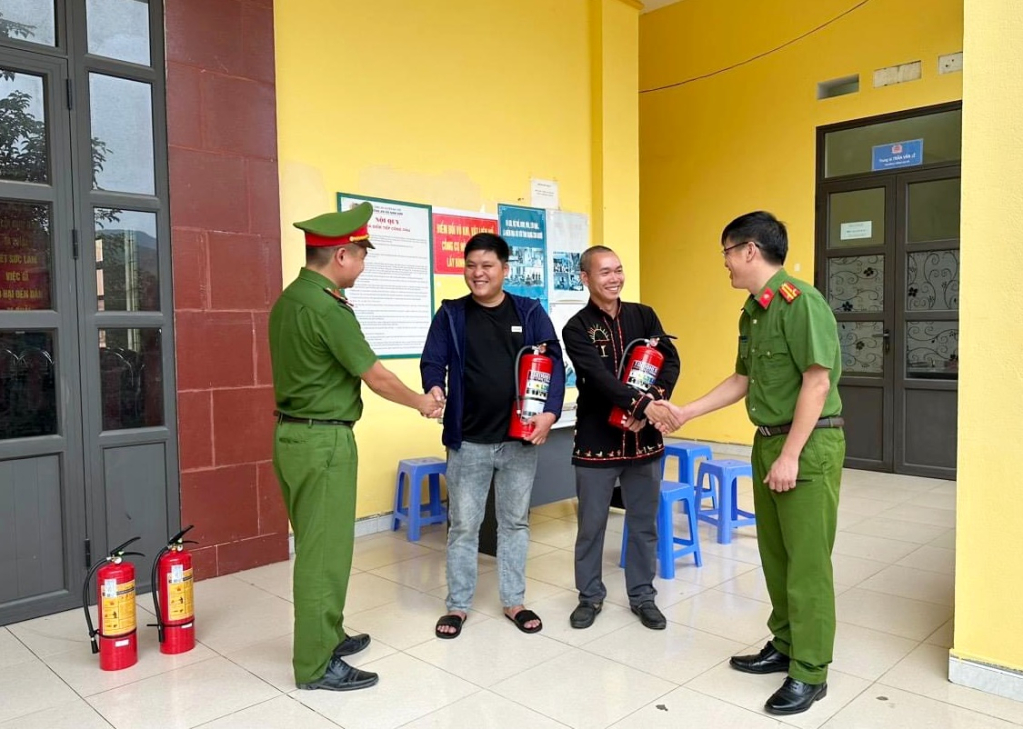 Người dân xã Nam Sơn (huyện Ba Chẽ) được đổi bình chữa cháy sau khi giao nộp vũ khí tự chế cho Công an xã. Ảnh: Khánh Linh.