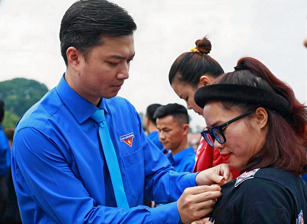 Anh Nguyễn Minh Triết - Bí thư Trung ương Đoàn, Chủ tịch Hội Sinh viên Việt Nam trao huy hiệu Thanh niên tiên tiến làm theo lời Bác cho cô giáo Nịnh Thị Vân.