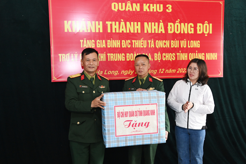 Thượng tá Phạm Quang Tiến, Phó Chủ nhiệm Chính trị Bộ CHQS tỉnh Quảng Ninh trao quà của Bộ CHQS tỉnh tặng gia đình Thiếu tá QNCN Bùi Vũ Long.