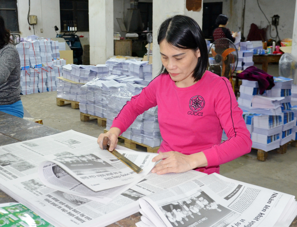 Chị Đỗ Thu Viên công nhân Phân xưởng Tổng hợp, Công ty TNHH MTV In Quảng Ninh thực hiện việc gấp báo thủ công.