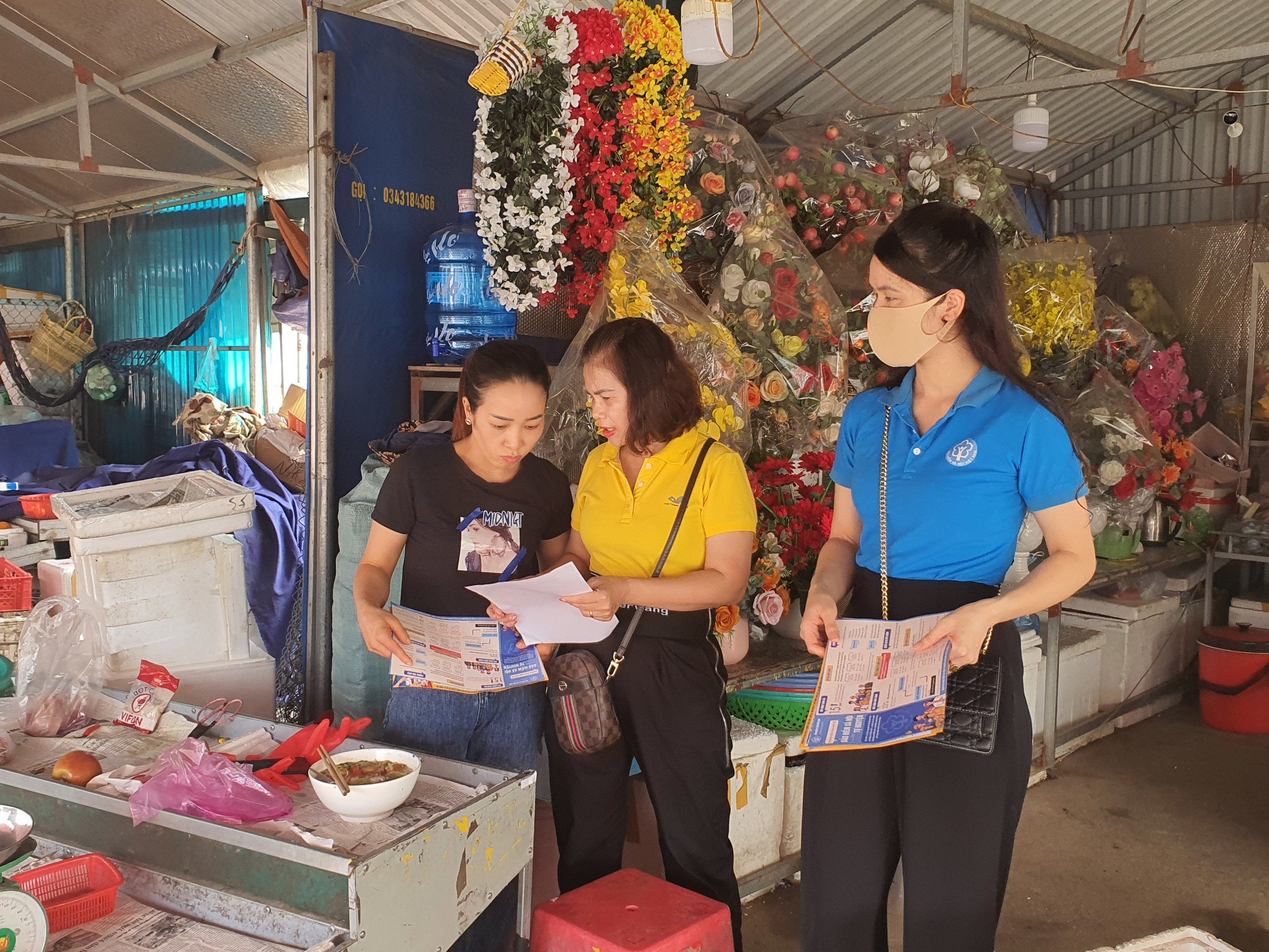 Nhân viên BHXH huyện Hải Hà tuyên truyền, hướng dẫn các tiểu thương chợ trung tâm Hải Hà 2 (huyện Hải Hà) tham gia BHXH tự nguyện.