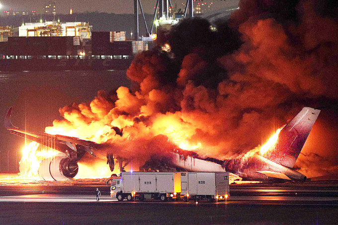 Phi cơ của Japan Airlines bị ngọn lửa bao trùm ở sân bay Haneda, Tokyo ngày 2/1. Ảnh: AFP