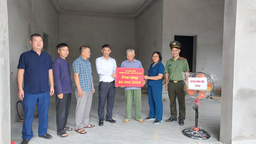 Lãnh đạo huyện Bình Liêu thay mặt các nhà hảo tâm TP Hạ Long trao tặng kinh phí hỗ trợ xây nhà mới cho gia đình ông Vy Đạt Phú (khu Nà Kẻ, thị trấn Bình Liêu).