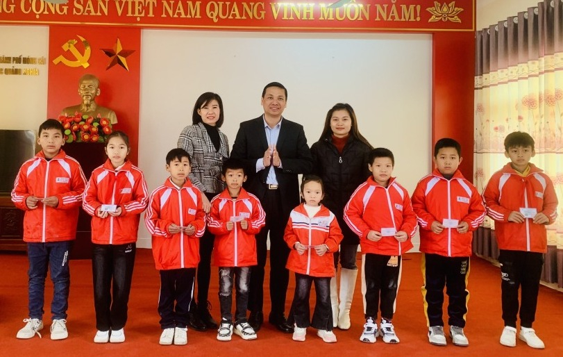 Lãnh đạo BHXH thành phố Móng Cái trao thẻ BHYT cho các em học sinh có hoàn cảnh khó khăn tại Trường tiểu học Quảng Nghĩa. Ảnh: Hải Ninh (TTTT&VH TP Móng Cái).