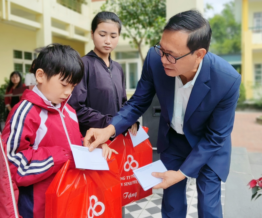 Ông Lãnh Thế Vinh, Chủ tịch Hội Bảo trợ NKT-TMC tỉnh tặng quà Tết cho học sinh khó khăn tại Trường TH&THCS Tràng Lương (TX Đông Triều).